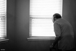 Eldre mann kikker ut av vindu (image)