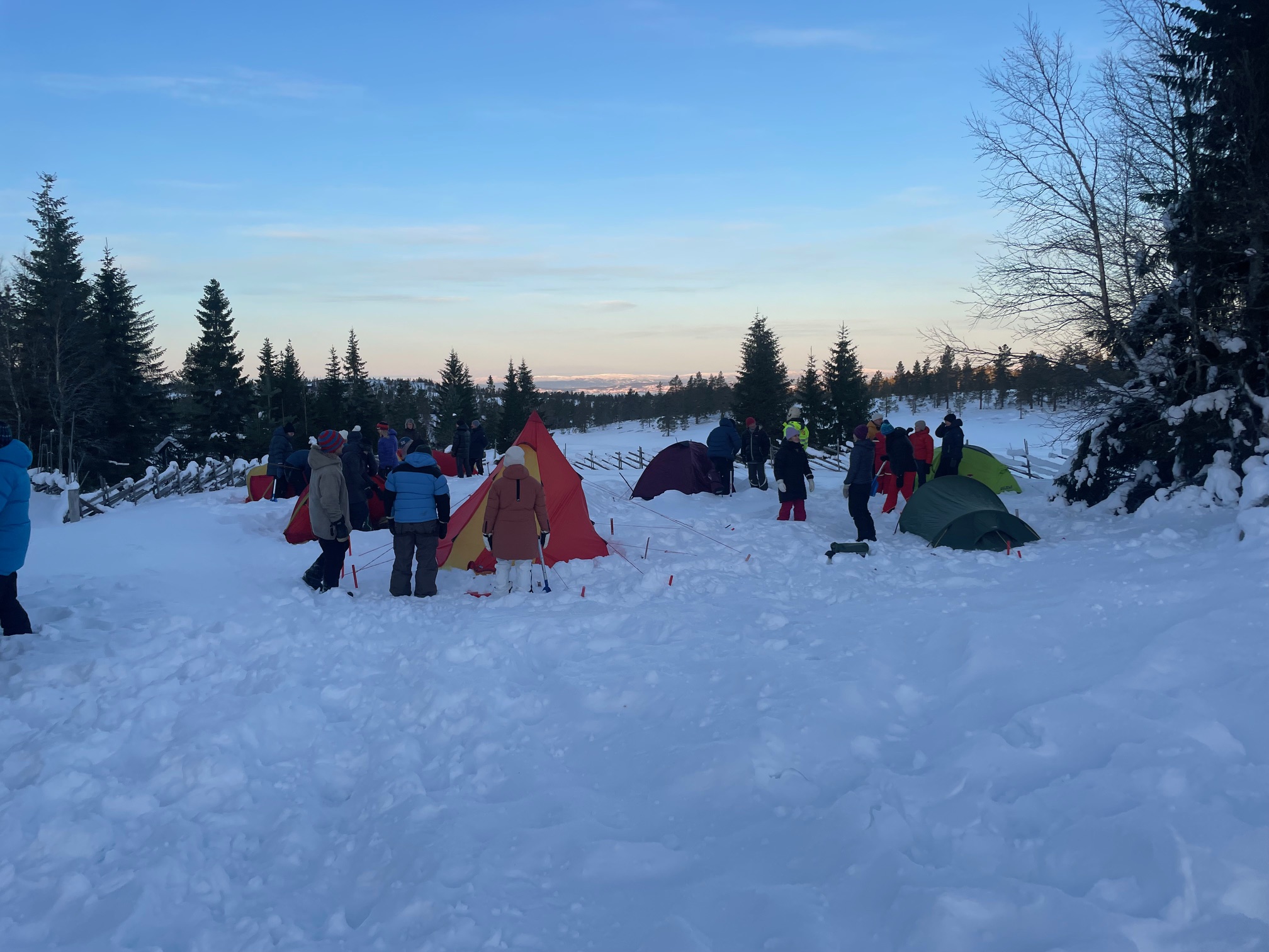 Vinterbilde av en gjeng som setter opp telt.