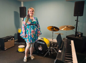 Bilde av en kvinne som står i et rom med musikkinstrumenter