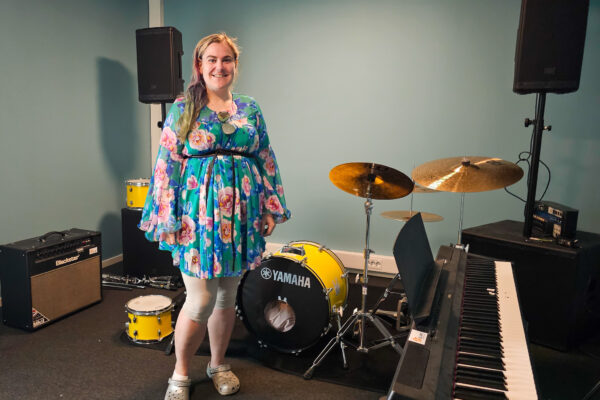 Bilde av en kvinne som står i et rom med musikkinstrumenter