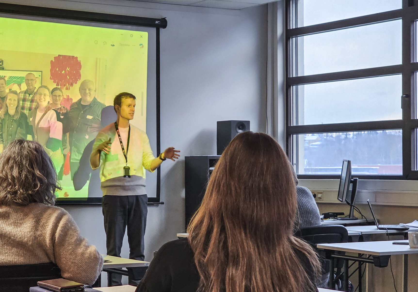 Bilde fra et klasserom, hvor en ung mann holder foredrag for flere