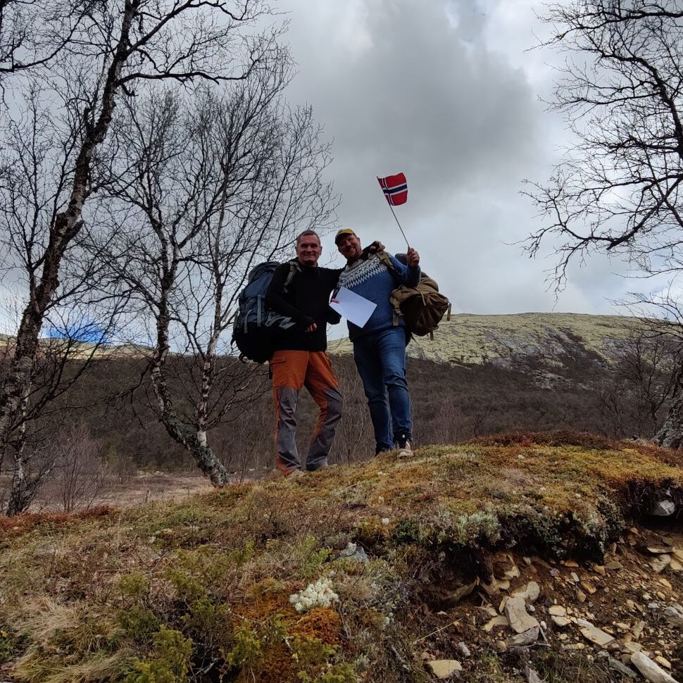 Raymond og Stian feirer oppstart av Norsk forneing for utendørsterapi. De feirer med flagg i marka.